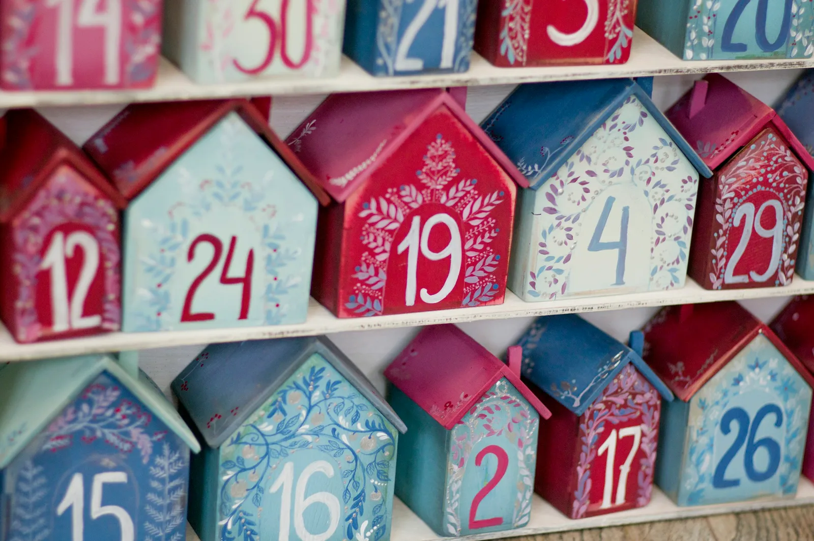 Calendrier de l'Avent en petites maisons de bois peintes en rouge et bleu, numérotées