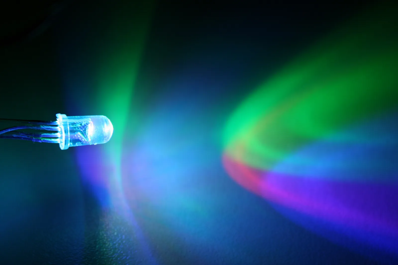 Lumière d'une diode LED projetée sur un mur sombre en halos rouge, vert et bleu